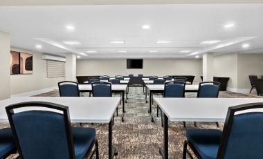 A conference room featuring tables and chairs, designed for meetings at Latitude Suites near Netflix in New Jersey.