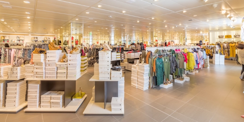 A spacious clothing store filled with various garments on display, located in Monmouth Mall, Jersey Shore.