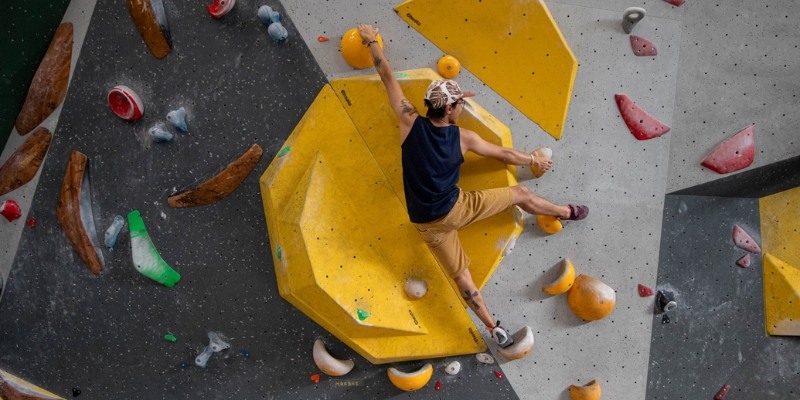A man climbing a rock wall indoors, showcasing an exciting activity at Jersey Shore's rock climbing venue.