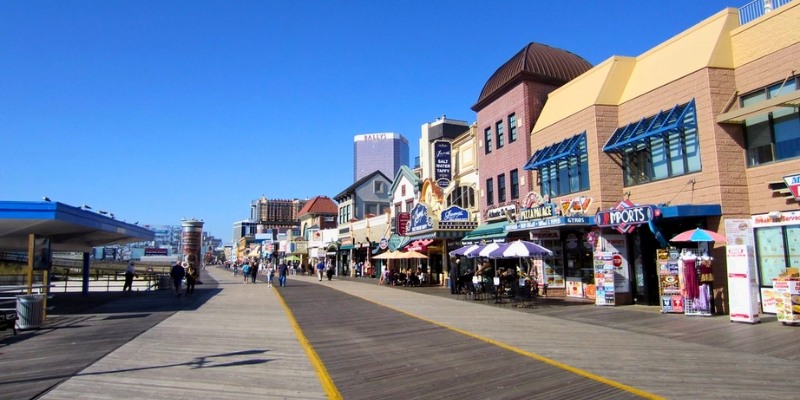 A vibrant boardwalk in Atlantic City lined with shops and restaurants on both sides, showcasing the Jersey Shore experience.