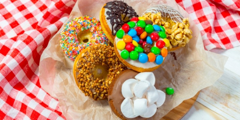 A plate featuring an assortment of colorful donuts and fluffy marshmallows, highlighting Jersey Shore boardwalk treats.