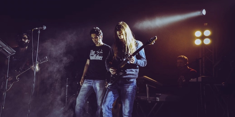 Two musicians playing guitar on stage at The Stone Pony, with a microphone in front, during a live music event.