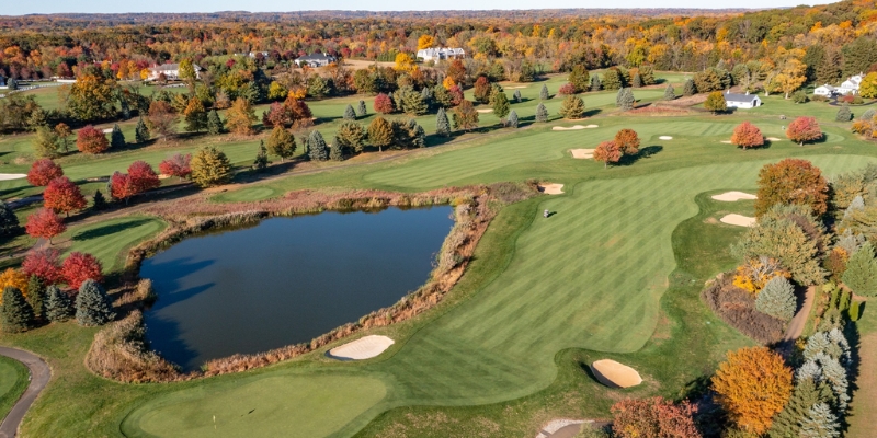 Aerial view of Colt’s Neck Golf Club, showcasing a golf course framed by vibrant fall foliage in Jersey Shore.