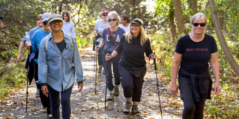 A group of people walking along a trail in Hartshorne Woods Park, enjoying outdoor activities at Jersey Shore.