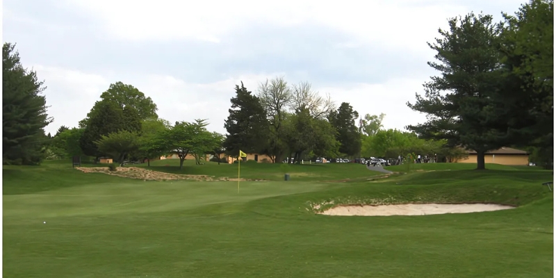 A scenic view of Shark River Golf Course featuring a bunker and trees, highlighting outdoor activities at Jersey Shore.