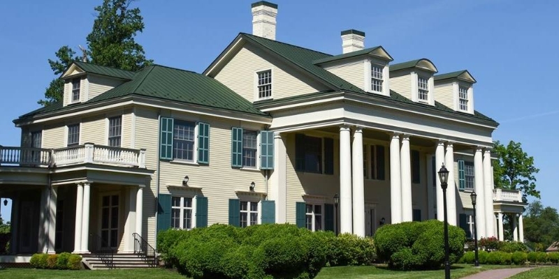 Thompson Park in Lincroft features a large house with an expansive porch, ideal for enjoying outdoor activities at Jersey Shore.