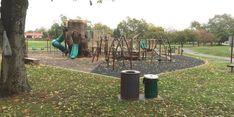 Outdoor playground at Wolcott Park, showcasing a slide and a tree stump, perfect for children's play at Jersey Shore.