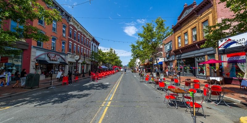 Outdoor dining setup with tables and chairs placed in the middle of a street in Downtown Red Bank near the Tinton Falls, NJ.