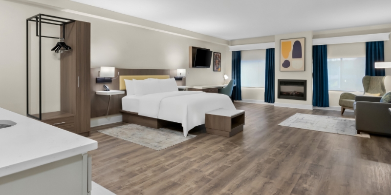 Cozy hotel room with a bed, desk, and television, perfect for guests visiting Latitude Suites near the Tinton Falls, NJ.