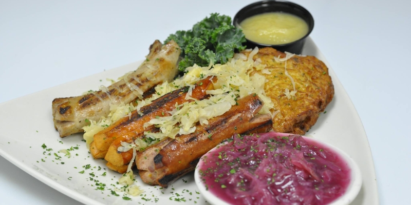 A close-up of a meat and vegetable on a plate, showcasing the menu at Pourhouse in Tinton Falls, NJ.