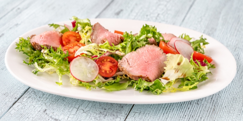 A colorful salad served on a plate, highlighting a dining experience at Woody’s Ocean Grille near Tinton Falls, NJ.