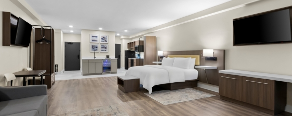 Comfortable hotel room with a bed, desk, and TV, ideal for extended stays close to Monmouth University.