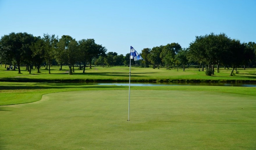 A scenic view of Bel-Aire Golf Course at Jersey Shore, featuring a flag on the green amidst lush fairways.