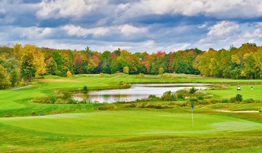 Scenic view of Hominy Hill Golf Course featuring a pond surrounded by lush trees at the Jersey Shore.