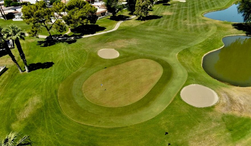 Aerial view of Trump National Golf Club at Jersey Shore, showcasing a golf course with a pond surrounded by lush greenery.