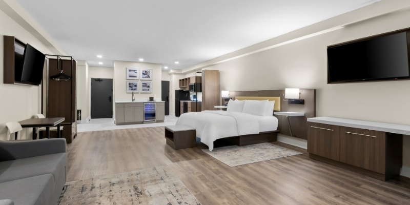 Contemporary hotel room showcasing a bed, desk, and television, ideal for guests at Latitude Suites, Jersey Shore.