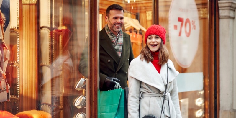 A man and woman are seen walking by a store window at the Jersey Shore Premium Outlets, highlighting winter shopping.