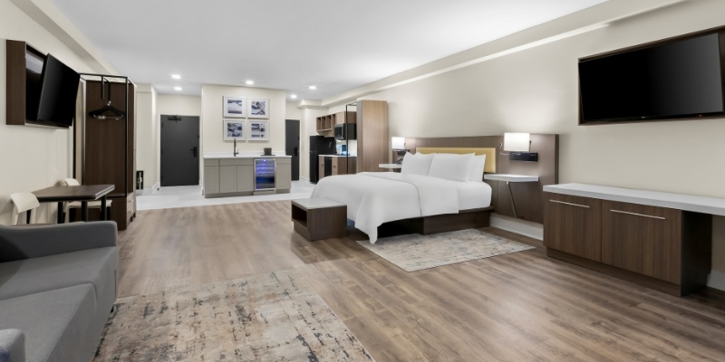 A modern hotel room featuring a bed, desk, and television, ideal for travelers at the Jersey Shore.