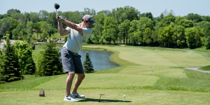A man is about to hit a golf ball on a well-maintained course, representing summer golfing options in New Jersey.