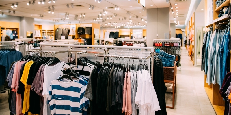 A clothing store interior featuring various clothes displayed on racks at Jersey Shore Premium Outlets in New Jersey.