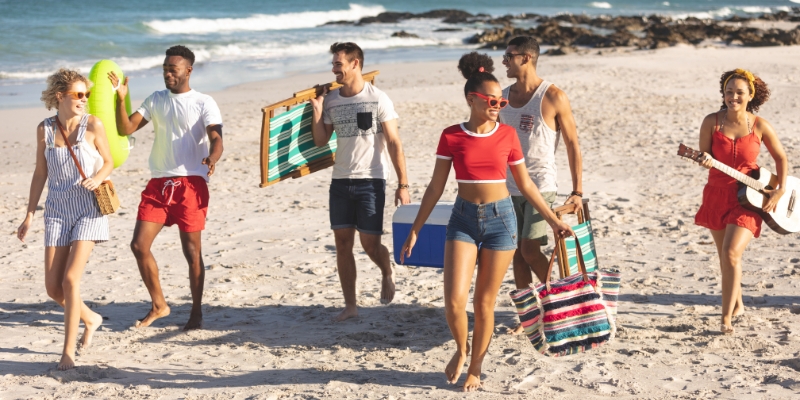 A lively group of young people walks on the beach, highlighting summer activities in New Jersey.