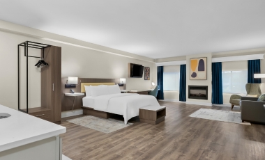 Cozy hotel room with a bed, desk, and television, ideal for guests attending events at the Count Basie Center for the Arts.