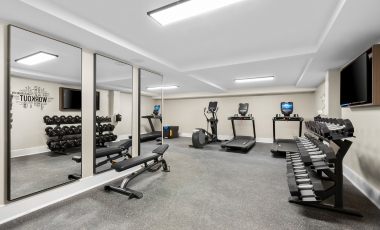 A gym room featuring mirrors and various fitness equipment, located in a hotel near the Count Basie Center for the Arts.