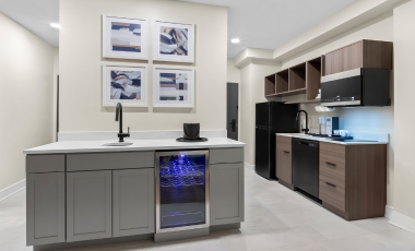 A hotel kitchenettes featuring a refrigerator, microwave, and sink, located near the Stone Pony.