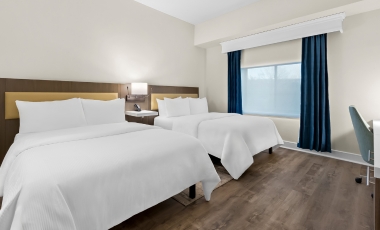 Hotel Near Wall Stadium Speedway - Spacious Two Room Suites Two beds, a desk, and a television in a hotel room, emphasizing the spacious suites available near Wall Stadium Speedway.