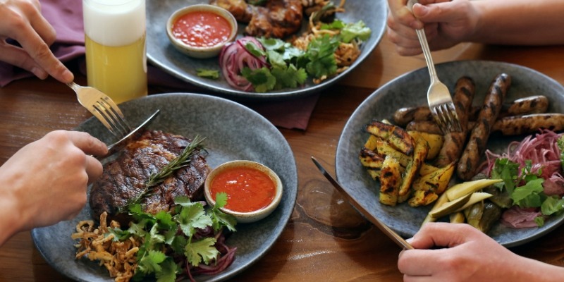 A group of people enjoying a meal together on plates during the New Jersey Shore itinerary, Day 3 afternoon.
