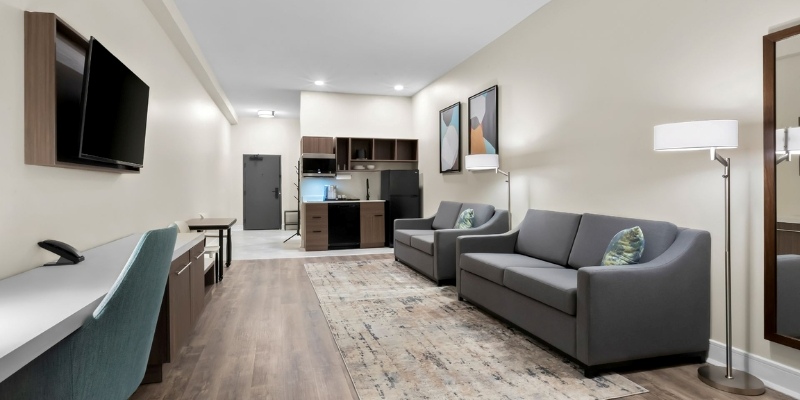 Hotel room featuring a couch, television, and kitchenette at Latitude Suites, perfect stay for New Jersey Shore itinerary.