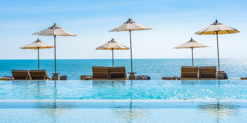 Scenic view of the beach and pool at a beach resort in Thailand, showcasing relaxation and luxury by the water.