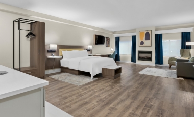 Comfortable hotel suite with a bed, desk, and television, located near the Asbury Park Zombie Walk event.