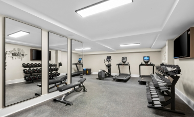 Modern fitness center featuring mirrors and various exercise equipment in a hotel near Tinton Falls Shopping Center.