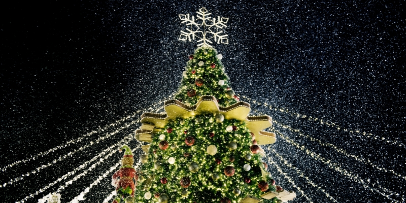 A Christmas tree adorned with snow and colorful lights, set against the backdrop of the Christmas Jersey Shore in Long Branch.