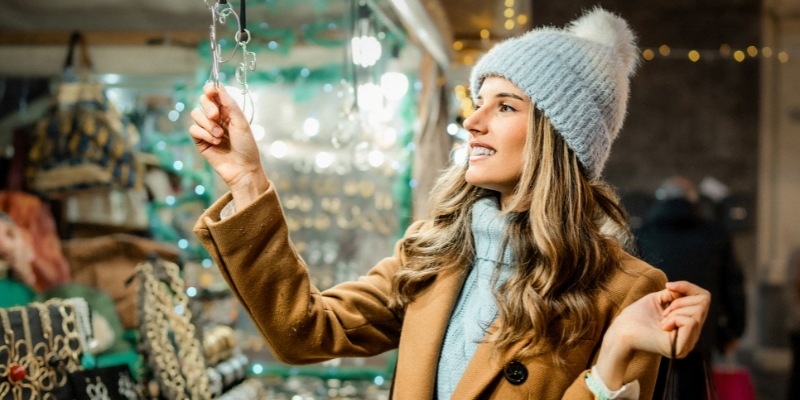 A woman observes a beautifully arranged window display of Christmas decorations, highlighting the spirit of the Jersey Shore.
