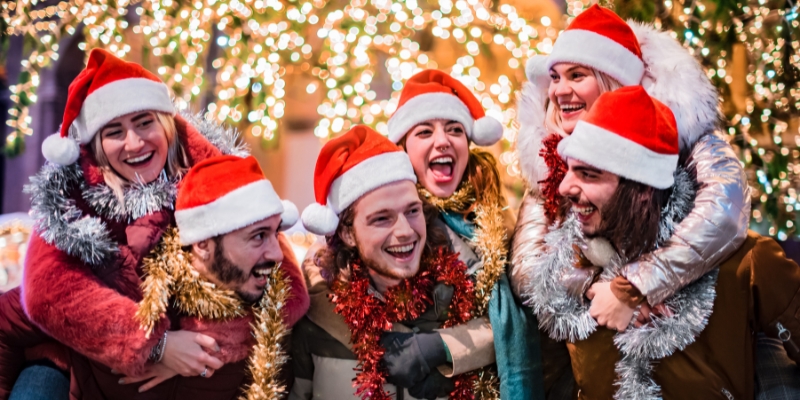 A group of friends wearing Santa hats, celebrating Christmas together at the Jersey Shore.