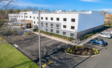 Exterior view of the Latitude Suites, featuring contemporary architecture and nearby parking options.