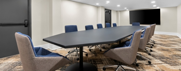 Conference room featuring a large table and chairs, located in a hotel near Monmouth Battlefield State Park for meetings.