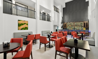 Hotel near Monmouth Mall - Onsite Dining & Bar Stylish restaurant with red chairs and tables, situated in a hotel near Monmouth Mall, providing onsite dining and bar services.