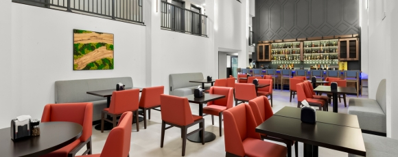 Modern restaurant featuring red chairs and tables, located at a hotel near Monmouth Museum with onsite dining options.