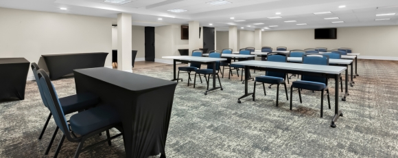 Conference room with tables and chairs, set up for meetings at a hotel near Monmouth Museum.