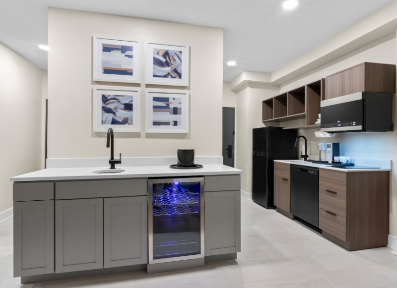 Hotel kitchen equipped with a refrigerator, microwave, and sink, situated near Trump National Golf Club.