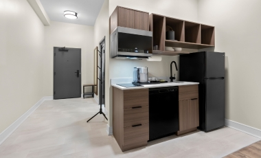 Hotel full kitchen equipped with a refrigerator, microwave, and sink, situated near Trump National Golf Club.