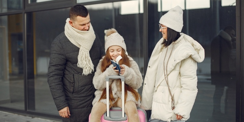 A family with a child sitting on a suitcase, preparing for New Year’s Eve celebrations at the Jersey Shore.