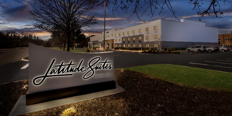 The Latitude Suites hotel sign shines at dusk, highlighting its New Year’s Eve offerings at the Jersey Shore.