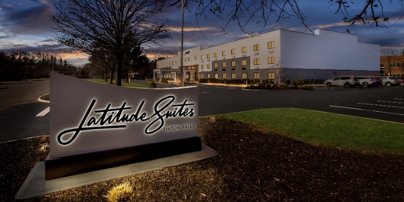 Evening view of The Latitude Suites hotel at the Jersey Shore, showcasing its inviting exterior and warm ambiance.