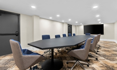 Hotel Near Sterling Ballroom - Event Space Conference room featuring chairs arranged around a large screen, located in the Hotel Near Sterling Ballroom event space.