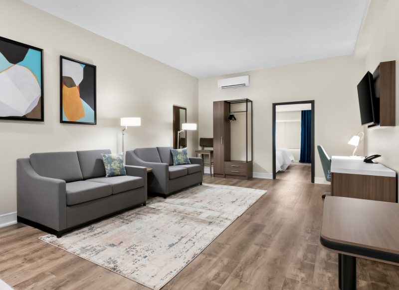 Cozy hotel room with a couch, desk, and TV, situated near Twin Lights Historic Site.