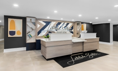 Lobby of Latitude Suites, featuring a 24-hour front desk and modern decor, near Twin Lights Historic Site.